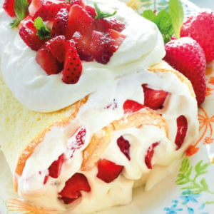 Cake topped with whipping cream and strawberries.