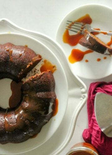 Gingerbread Cake with Caramel Sauce on White Cake Platter.
