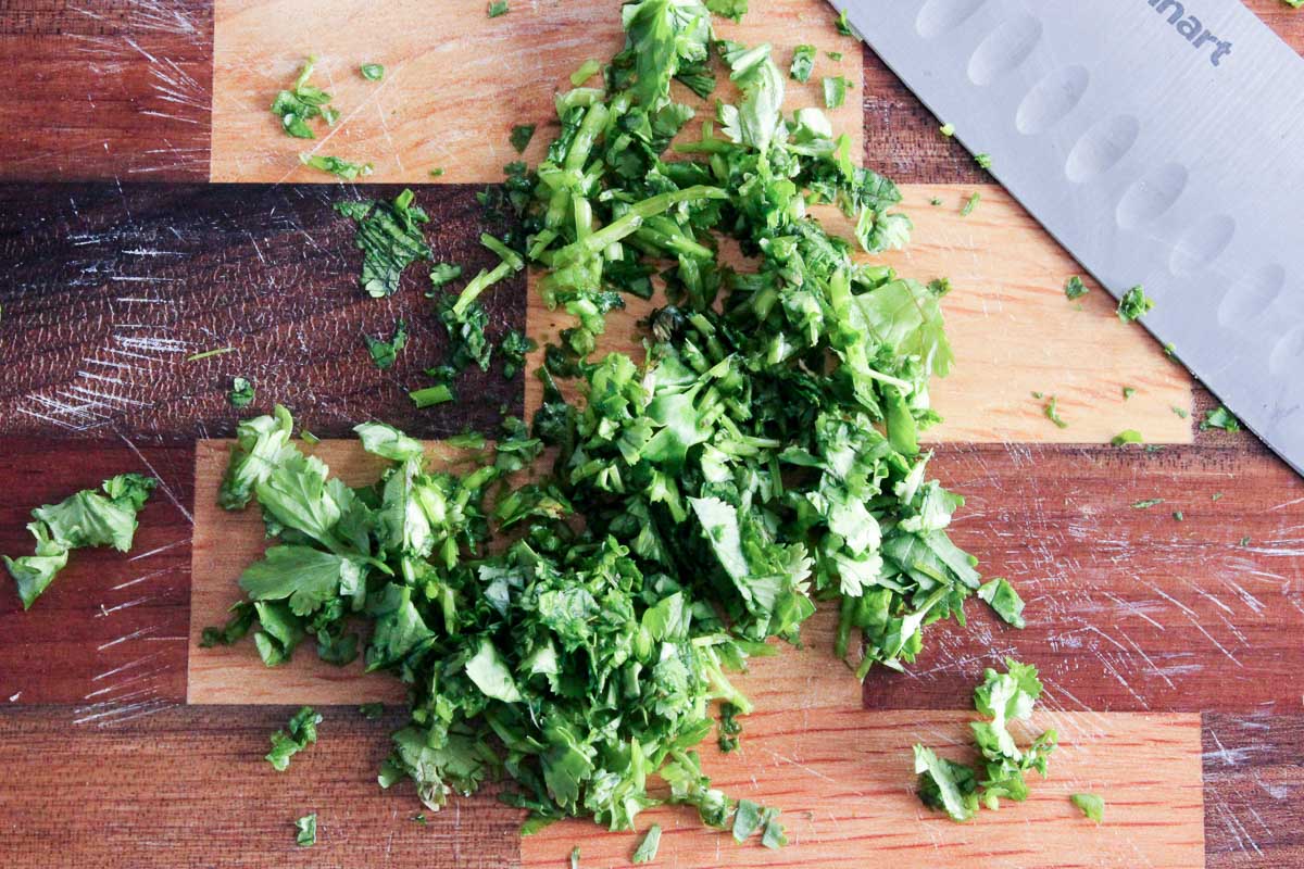 Chopped cilantro on wooden cutting board