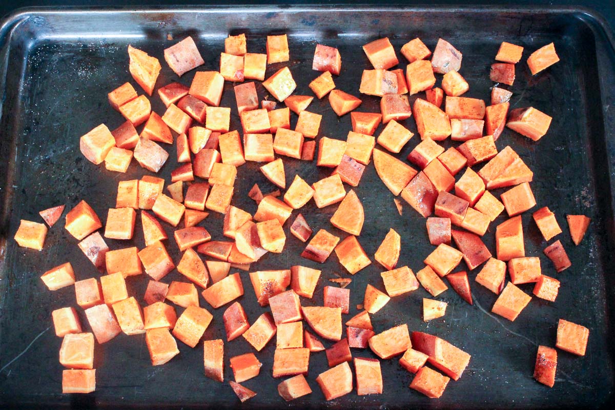 Sheet pan of cubed sweet potatoes with taco seasoning