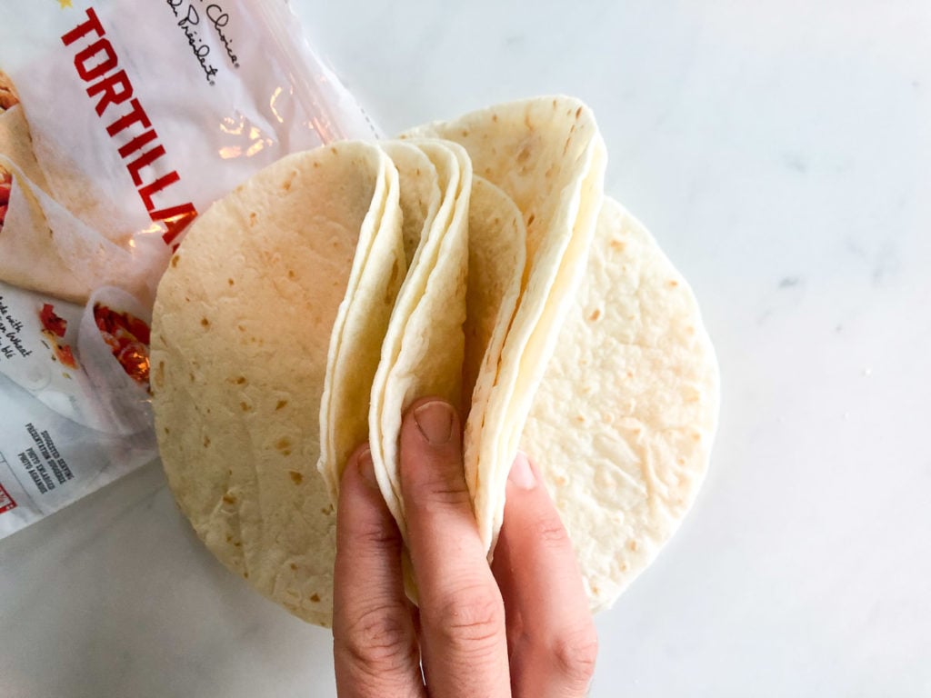 Stack of flour tortillas held up by hand